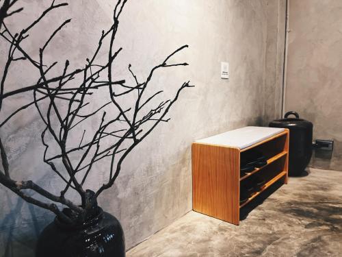 a black vase with a plant in a room at Yu Apartment in Jiufen