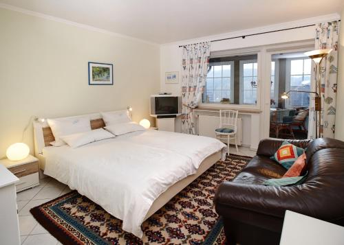 a bedroom with a large bed and a leather couch at Ferienwohnung Stölben in Daun