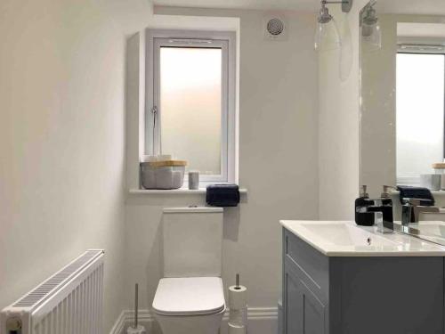 a white bathroom with a toilet and a sink at The View in Leeds