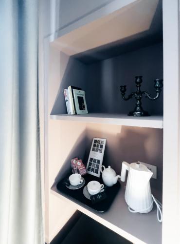a shelf with a phone and a tea kettle at Caffè delle Rose Les Chambres in Verbania