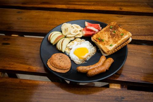 a plate of breakfast food with eggs sausage and toast at Trippers hostel in Darjeeling