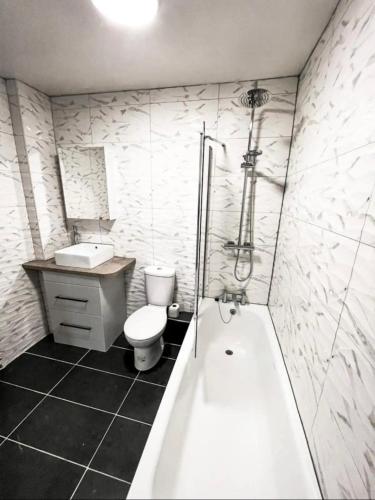 ein Badezimmer mit Badewanne, Toilette und Waschbecken in der Unterkunft Lovely 1-bedroom apartment, free street parking in Elswick