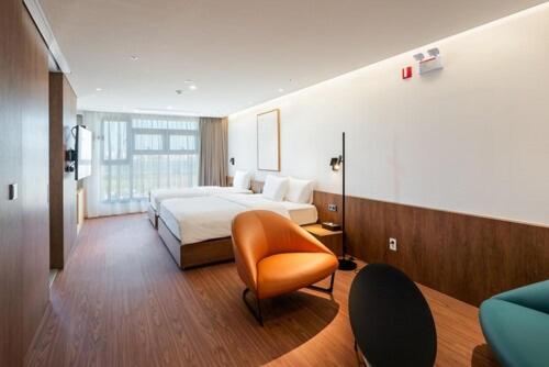 Pokój hotelowy z łóżkiem i krzesłem w obiekcie Hotel Cielo w mieście Siheung