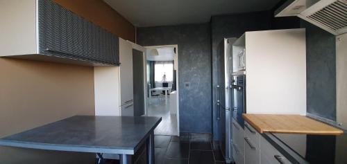 uma cozinha com um balcão preto num quarto em Chambre chez l'habitant - Appartement lumineux - Gare à 2 arrêts de tram em Fleury-les-Aubrais
