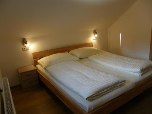 Schlafzimmer mit einem Bett mit weißer Bettwäsche und Kissen in der Unterkunft Apartment Altaussee in Altaussee