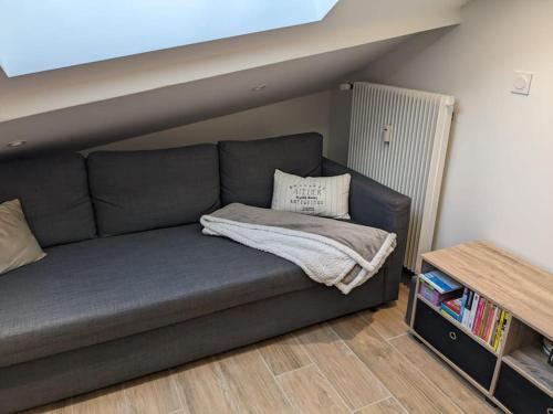 un sofá con una manta en una habitación en Magnifique appartement entièrement rénové au pied des pistes, en Métabief