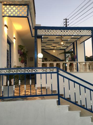 a house with a blue railing on a staircase at بيت العُمري (ام قيس) in Um Qeis