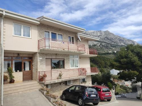 a house with two cars parked in front of it at Villa Arija Brela in Brela