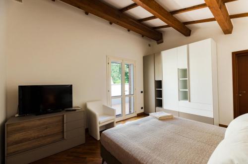 a bedroom with a bed and a flat screen tv at AMNESIA VILLAS in Borghetto