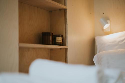 sypialnia z półką na książki obok łóżka w obiekcie Slowood Cabins w mieście Balatonszepezd
