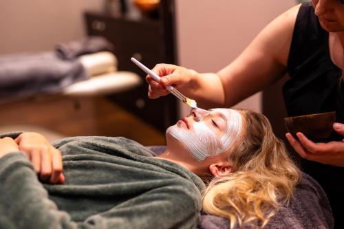 a woman getting her hair cut at a salon at Ferienhäuser Saalemaxx in Rudolstadt