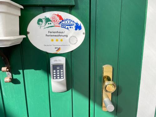 un cartel en una puerta con un celular en ella en Ruheoase im Grünen - Komfortable Ferienwohnung am Wulfskamp, Westerstede, en Westerstede