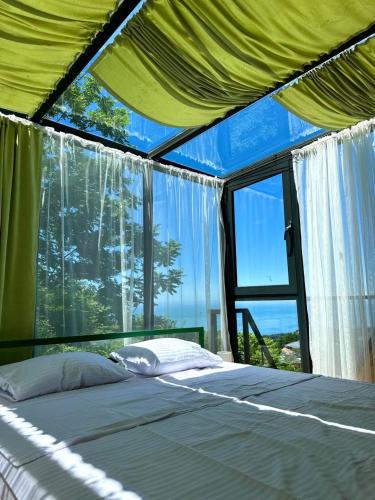 a bed in a tent with a large window at Nutshell in Sakhalvasho