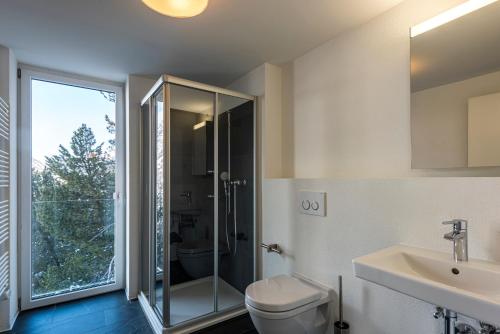 a bathroom with a shower and a toilet and a sink at Legendär Zermatt in Zermatt