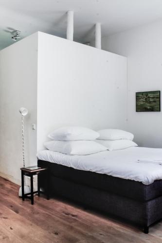 a white bedroom with a large bed with white pillows at de Lochemse Berg in Barchem