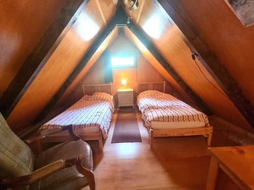 an attic room with two beds and a window at Chalet cosy 9 pers. avec balcon Sud, poêle à bois, Wi-Fi, proche pistes - Saint-Michel-de-Chaillol - FR-1-393-143 in Saint-Michel-de-Chaillol