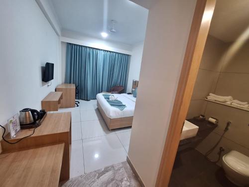 ein Hotelzimmer mit einem Bett und einem Bad in der Unterkunft RR Galaxy in Gurgaon