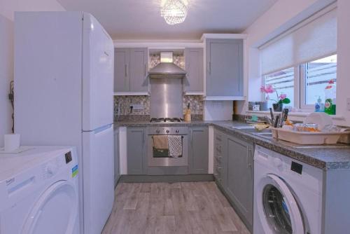 een keuken met een koelkast, een wasmachine en een droger bij Superb Leighton Street House in Liverpool