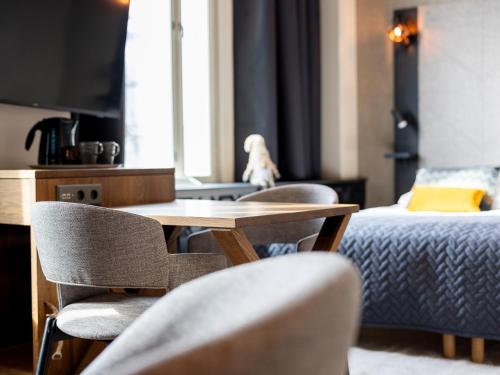 a room with a table and chairs and a bed at Santa's Hotel Santa Claus in Rovaniemi