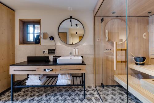 a bathroom with a sink and a shower at Hideaway Hotel Montestyria Chalets & Suiten in Mariazell