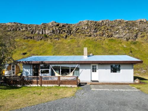 a house with a mountain in the background at Kamburinn Cottage in Hveragerði