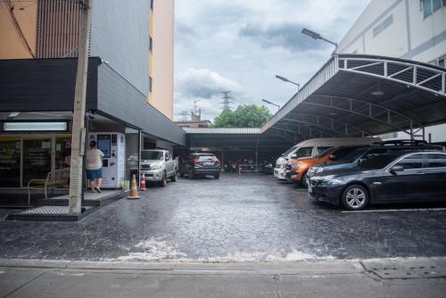 un parcheggio con auto parcheggiate di fronte a un edificio di JW Happy room Huaikhwang a Ban Na Song