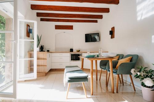 Il comprend une cuisine avec des plafonds en bois, une table et des chaises. dans l'établissement Appartement Residenz Bella Italia - Charmante Unterkunft im Herzen von Würzburg mit Balkon, Terrasse und Parkplatz im Innenhof!, à Wurtzbourg