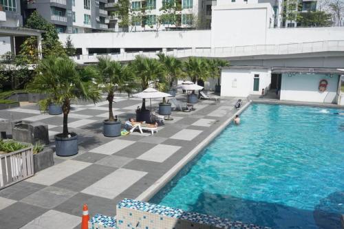 uma vista sobre uma piscina com palmeiras e guarda-sóis em Romance in de house 3-5pax Two Parking Free, There is a shopping mall downstairs em Kuala Lumpur
