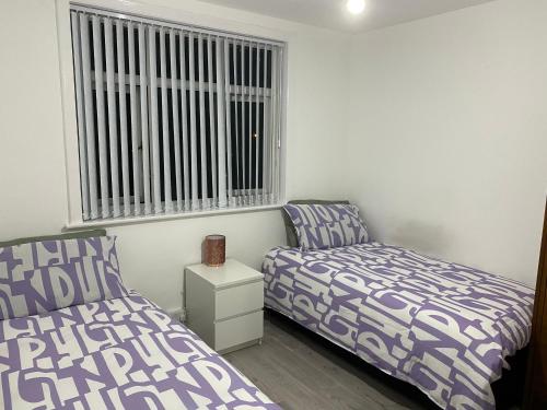 a bedroom with two beds and a window at Calm house twin beds in Wyken