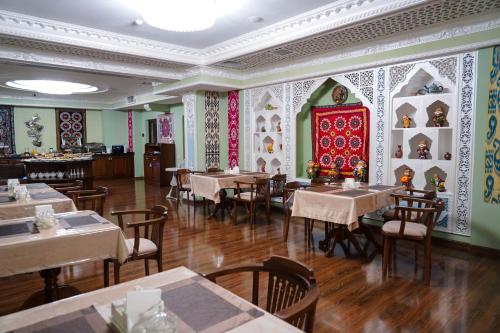 a restaurant with tables and chairs in a room at Sangzor Boutique Hotel in Samarkand