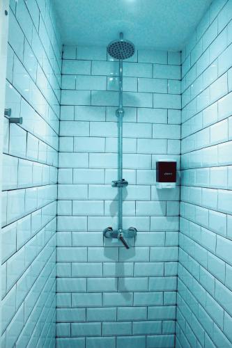 a bathroom with a shower with blue tiles at Feel Hostels Soho Malaga in Málaga