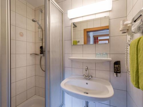 a white bathroom with a sink and a shower at Gasthof zur Post in Hinterriss