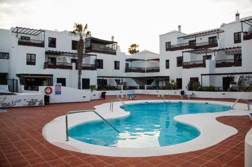 a large swimming pool in front of a building at Malvasía House in Costa Teguise