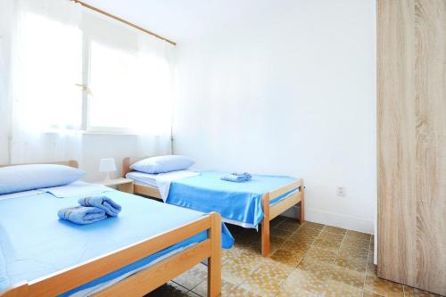 two beds in a room with blue sheets at Split Central Lovely Flat in Split