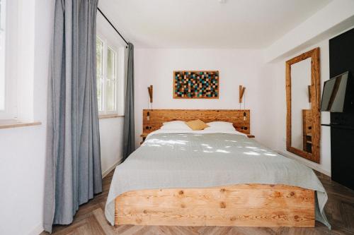 Schlafzimmer mit einem großen Bett mit einem Kopfteil aus Holz in der Unterkunft Appartement Residenz Bella Italia - Charmante Unterkunft im Herzen von Würzburg mit Balkon, Terrasse und Parkplatz im Innenhof! in Würzburg