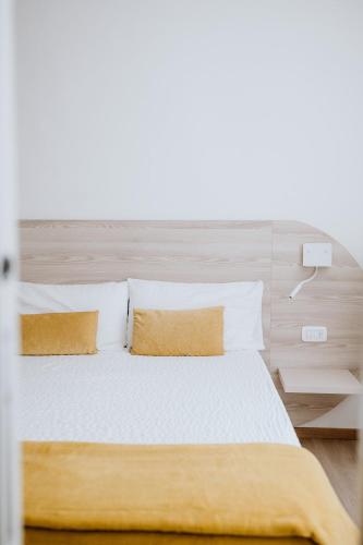 a bedroom with a bed with white sheets and pillows at Hotel Venezia in Trento