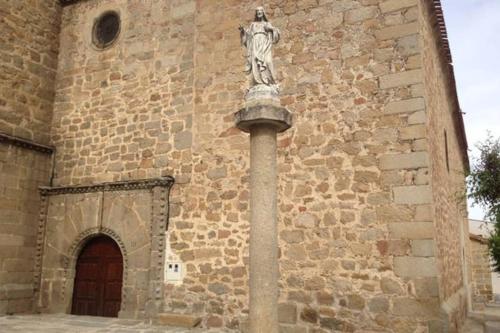 a statue on a pole in front of a building at Casa rural en El Burguillo -Vitalia 2 CR-AV-1251 in Las Cruceras