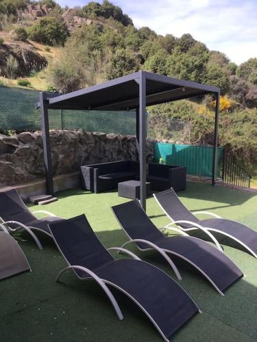 a group of chairs sitting under a pavilion at Casa rural en El Burguillo -Vitalia 2 CR-AV-1251 in Las Cruceras