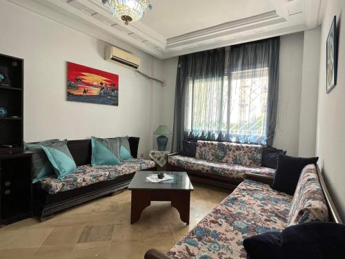 uma sala de estar com dois sofás e uma mesa de centro em Palmeraies vacances Tunis em La Marsa
