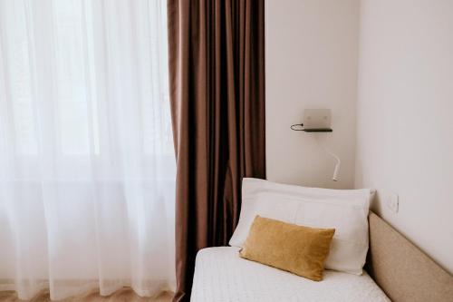 a bed with a pillow next to a window at Hotel Venezia in Trento