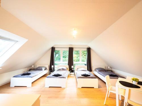 a attic room with three beds and a table at Apartment in Trappenkamp near Kiel in Trappenkamp