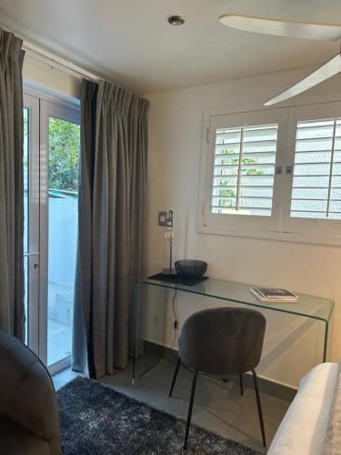 a desk in a room with a chair and a window at The Atlantic DonReal Guesthouse in Cape Town