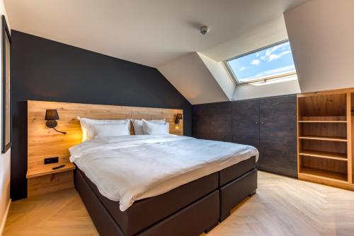 um quarto com uma cama grande e uma clarabóia em The Shelf - Gîte & Love room em Bastogne