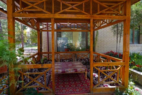 a wooden gazebo with a table in the middle at Sangzor Boutique Hotel in Samarkand