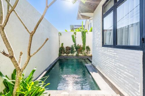 a swimming pool in the backyard of a house at Ambara Residence Villa in Canggu