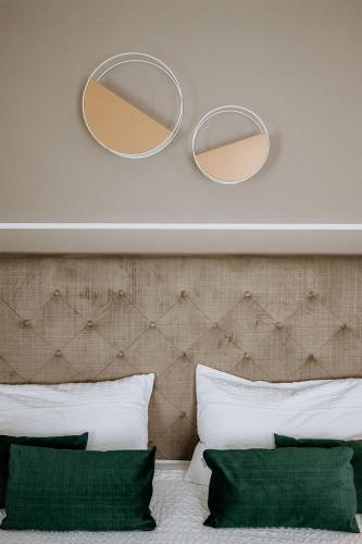 two mirrors on a wall above a bed with pillows at Hotel Venezia in Trento