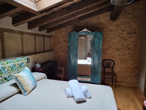 a bedroom with a bed and a mirror at La Casa El Cura in Madrigal de la Vera