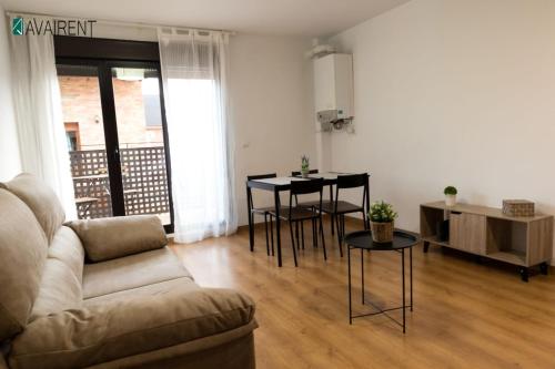 a living room with a couch and a table and chairs at El Serrablo AVAIRENT Sabiñánigo in Sabiñánigo