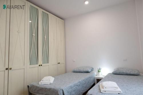 a bedroom with two twin beds and a cabinet at El Serrablo AVAIRENT Sabiñánigo in Sabiñánigo