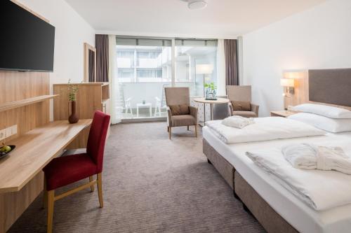 um quarto de hotel com duas camas e uma secretária em Hotel Frankenland em Bad Kissingen